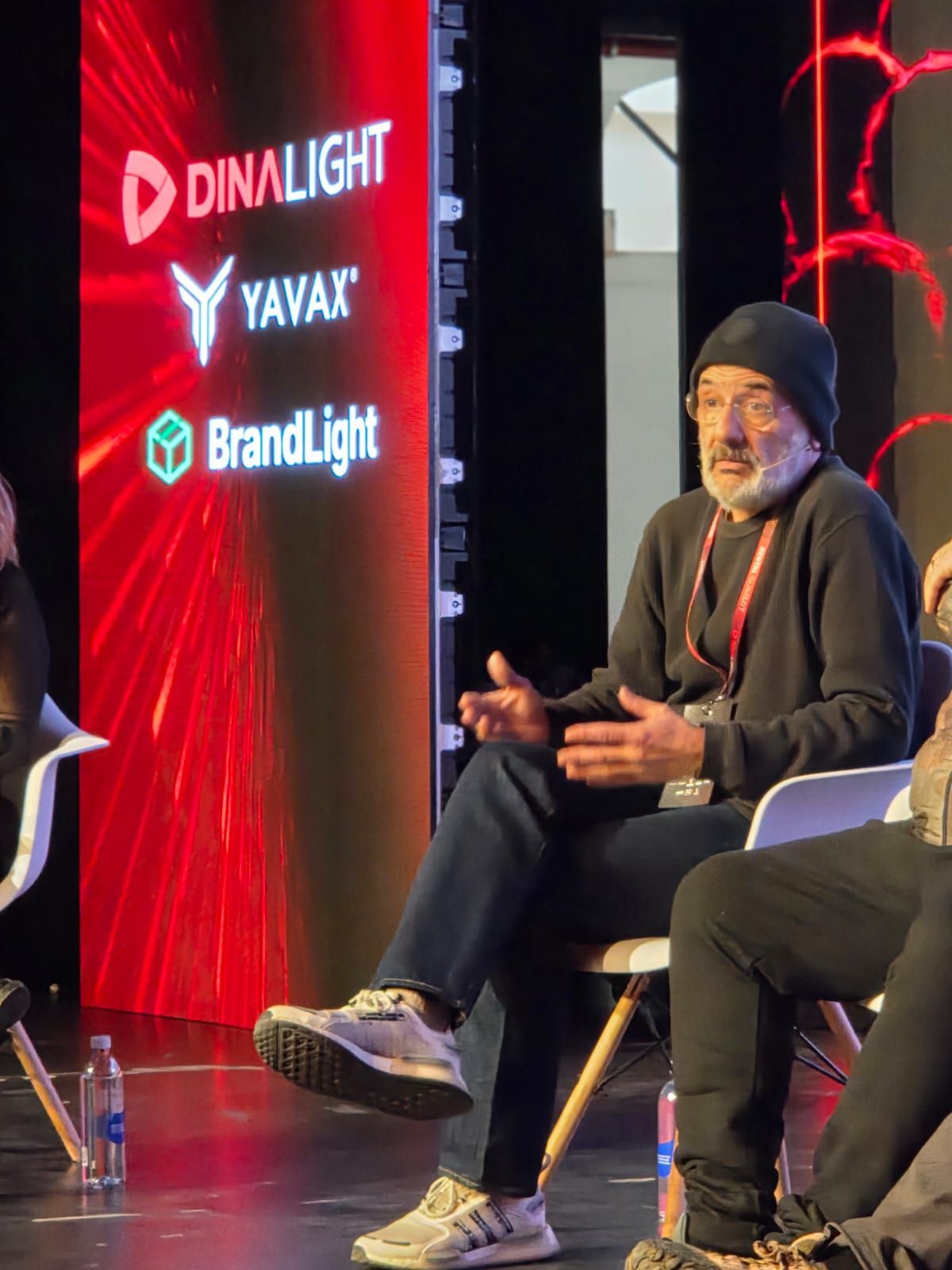 Speaker durante su charla en el escenario, con el LED de Dinalight, Yavax y BrandLight de fondo