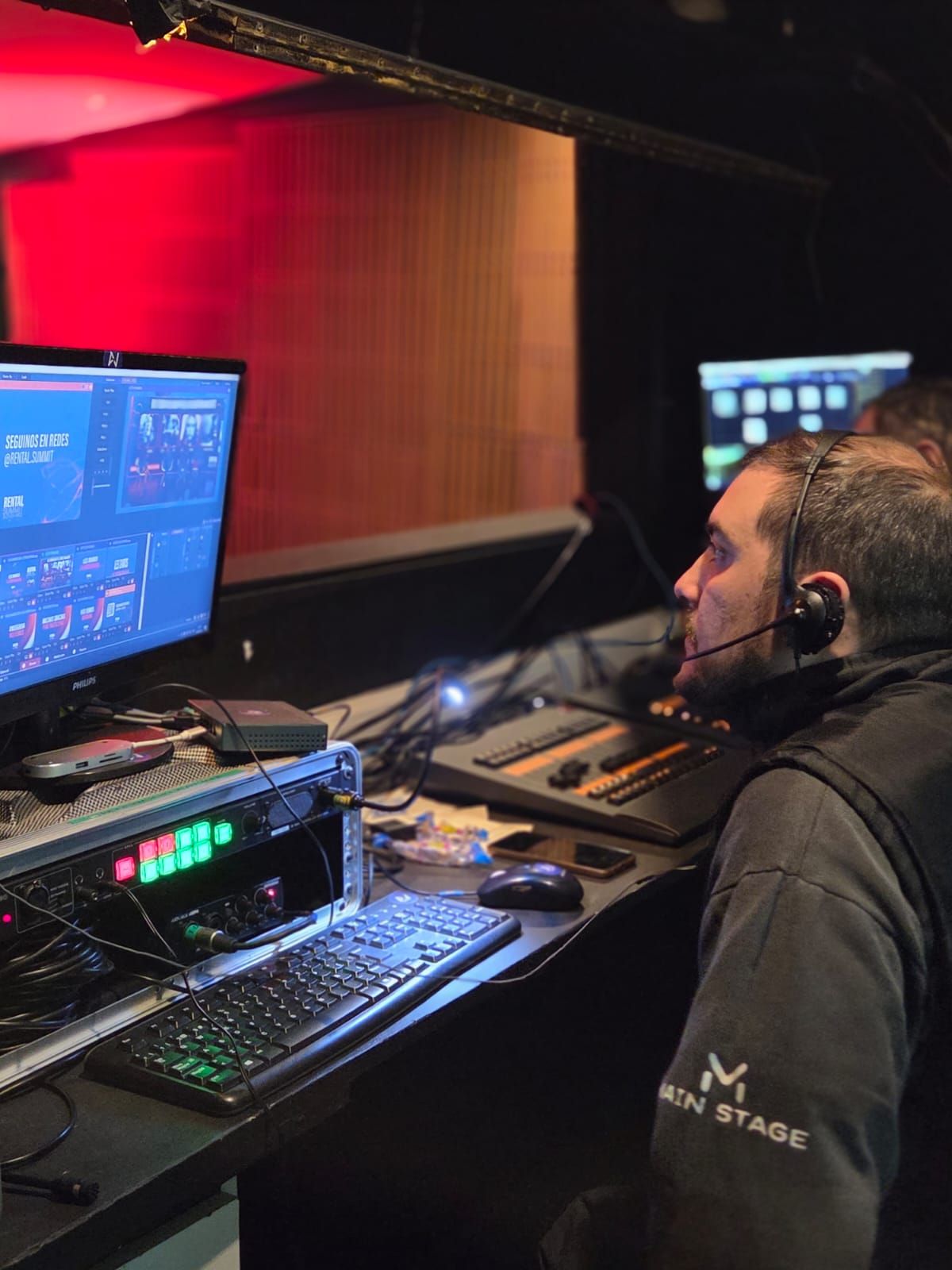 Operador técnico con intercom frente a los monitores de control