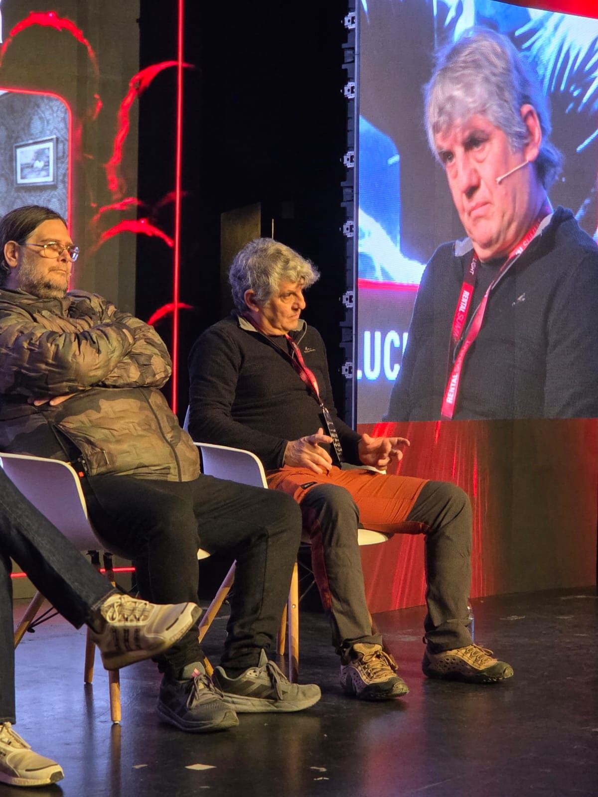 Dos panelistas conversando en el escenario durante una de las mesas del Summit